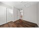 Minimalist bedroom features hardwood floors and a closet with bright white folding doors at 1027 Koss St, Erie, CO 80516