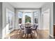 Bright dining area with a bay window, white drapes, and classic hardwood floors at 1027 Koss St, Erie, CO 80516