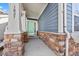 Charming front porch with blue siding, stone accents, and a welcoming light blue door at 1027 Koss St, Erie, CO 80516