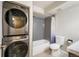 Modern bathroom featuring a stacked washer and dryer unit and a shower-tub combo with gray tiling at 50 S Boulder Cir # 5022, Boulder, CO 80303