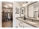 Elegant bathroom featuring granite countertops, double sinks, modern fixtures and a view into the walk-in closet at 3549 Swabuck Pl, Castle Rock, CO 80109