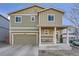 Charming two-story home with green siding, a covered front porch, and an attached two car garage at 3549 Swabuck Pl, Castle Rock, CO 80109