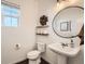 Modern half bathroom with pedestal sink, stylish decor, round mirror and wood accents at 3549 Swabuck Pl, Castle Rock, CO 80109