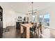 Bright kitchen and dining area with stainless steel appliances, modern lighting, and sliding glass doors at 3549 Swabuck Pl, Castle Rock, CO 80109