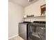 Functional laundry room features modern, front-loading machines and ample shelving for storage at 3549 Swabuck Pl, Castle Rock, CO 80109