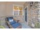 Inviting entryway with stone wall, wicker chair, and small side table at 12910 W Burgundy Dr, Littleton, CO 80127