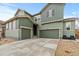 Two-story home with a three-car garage and neutral green color scheme at 17880 W 94Th Dr, Arvada, CO 80007