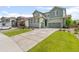 Beautiful home with a well-manicured lawn, a long driveway, and charming green siding at 17880 W 94Th Dr, Arvada, CO 80007