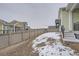 Backyard with partially snow-covered ground and wooden privacy fence at 1885 Hickory Ave, Erie, CO 80516