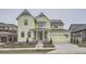 Two-story light green house with a large front porch and attached two-car garage at 1885 Hickory Ave, Erie, CO 80516