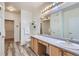 Bathroom featuring a double vanity, toilet, walk-in closet, and decorative plants on floating shelves at 4222 S Blackhawk Cir # 6G, Aurora, CO 80014