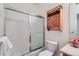 Bright bathroom featuring a shower-tub with sliding glass door and wooden cabinet at 4222 S Blackhawk Cir # 6G, Aurora, CO 80014