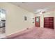 Bright living room featuring pink carpet, built-in bookcase, and entryway to kitchen with stainless steel appliances at 4222 S Blackhawk Cir # 6G, Aurora, CO 80014