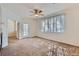 Living room featuring plush carpeting, a ceiling fan, and a large window with blinds at 4222 S Blackhawk Cir # 6G, Aurora, CO 80014