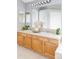 Bathroom featuring a double vanity with wood cabinets, tile floors, and decorative mirrors at 7700 Bison Ct, Littleton, CO 80125