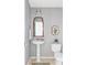 Cozy powder room with pedestal sink, toilet, and decorative mirror at 7700 Bison Ct, Littleton, CO 80125