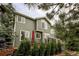 Exterior of a home with green siding showcasing a brick patio, red umbrella and well-maintained landscaping at 7700 Bison Ct, Littleton, CO 80125