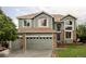 Inviting two-story home featuring a three-car garage, brick accents, and a beautifully landscaped front yard at 7700 Bison Ct, Littleton, CO 80125
