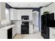 Well-equipped kitchen with white cabinets, modern appliances, and stylish backsplash at 7700 Bison Ct, Littleton, CO 80125