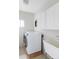 Functional laundry room with washer, dryer, sink, and white cabinets for storage at 7700 Bison Ct, Littleton, CO 80125
