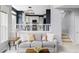 Cozy living room with fireplace, modern lighting, and view into the kitchen at 7700 Bison Ct, Littleton, CO 80125