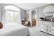 Serene primary bedroom featuring an arched window, carpet floors, and a glimpse of the en-suite bathroom at 7700 Bison Ct, Littleton, CO 80125