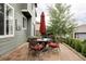 Brick patio featuring a round glass table and cushioned seating with a closed red umbrella and green siding at 7700 Bison Ct, Littleton, CO 80125