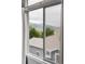 Picturesque window view overlooking rooftops, lush trees, and distant hills at 7700 Bison Ct, Littleton, CO 80125