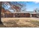 Back of house with brick exterior, covered patio, and a wide-open backyard at 6960 S Penrose Ct, Centennial, CO 80122