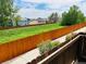 View of the green backyard and neighboring houses from the fence line at 12036 Monaco St, Brighton, CO 80602