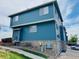 Stylish townhouse exterior with stone accents, blue siding, and well-maintained landscaping at 12036 Monaco St, Brighton, CO 80602