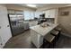 Modern kitchen with a breakfast bar, dining area, stainless steel appliances, and light wood flooring at 12036 Monaco St, Brighton, CO 80602