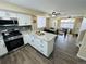 Modern kitchen with a breakfast bar, dining area, stainless steel appliances, and light wood flooring at 12036 Monaco St, Brighton, CO 80602