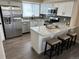 Modern kitchen with a breakfast bar, dining area, stainless steel appliances, and light wood flooring at 12036 Monaco St, Brighton, CO 80602