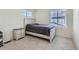 Bright bedroom featuring a bed, side table, soft carpet, and natural light from the bright windows at 9466 Quintero St, Commerce City, CO 80022
