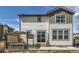 Two-story home exterior with sliding glass doors leading to an outdoor patio and well manicured landscaping at 9466 Quintero St, Commerce City, CO 80022