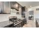 Kitchen with stainless appliances, granite countertops, and dark cabinets at 9466 Quintero St, Commerce City, CO 80022