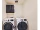 Well-equipped laundry room featuring a modern washer and dryer and convenient above-appliance storage cabinets at 9466 Quintero St, Commerce City, CO 80022