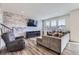 Inviting living room features a stone accent wall, recessed lighting, and wood floors at 9466 Quintero St, Commerce City, CO 80022