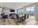 Open-concept living and dining area with a stone accent wall and large windows at 9466 Quintero St, Commerce City, CO 80022