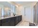 Bathroom features a double sink vanity with granite countertop and a glass-enclosed shower at 9466 Quintero St, Commerce City, CO 80022