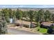 Scenic aerial view of a home nestled among lush trees with a distant view of rolling hills at 7904 Hill Crest Dr, Louviers, CO 80131