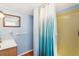Well-lit bathroom with a vanity, mirror, and shower featuring a blue and white curtain at 7904 Hill Crest Dr, Louviers, CO 80131