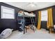 Cozy bedroom with a unique loft bed, dark walls, and natural light from the windows, creating a comfortable space at 7904 Hill Crest Dr, Louviers, CO 80131