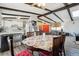 Dining area with exposed beams open to the kitchen, featuring a floral tablecloth and bright red accents at 7904 Hill Crest Dr, Louviers, CO 80131