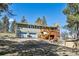 Multi-level home featuring a large deck, a two-car garage, and a spacious backyard at 7904 Hill Crest Dr, Louviers, CO 80131