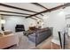 Cozy living room features exposed beams, carpet floors and an open staircase with a metal railing at 7904 Hill Crest Dr, Louviers, CO 80131