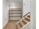 Unfinished basement space with carpeted stairs and open shelving for storage at 1315 Estes St # 13C, Denver, CO 80215