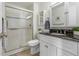 Modern bathroom with tile shower, glass door, and white vanity with black countertop at 1315 Estes St # 13C, Denver, CO 80215