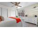 Bedroom featuring a bed, neutral walls, ceiling fan, dresser, and large window at 1315 Estes St # 13C, Denver, CO 80215